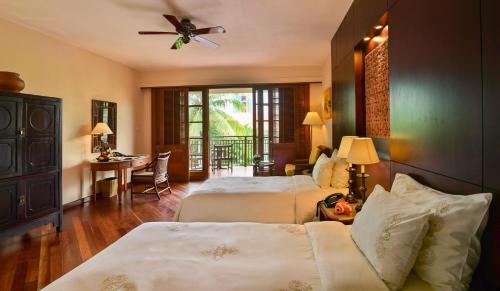 a hotel room with two beds and a table at Furama Resort Danang in Danang