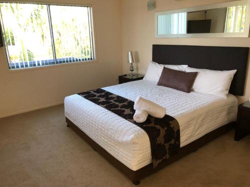 a bedroom with a large bed with a large window at Grange Resort Hervey Bay in Hervey Bay