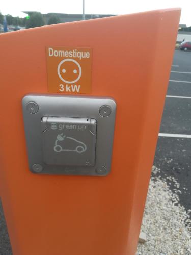 an orange parking meter with a car on it at Atao Residence- Rennes Sud in Vern-sur-Seiche