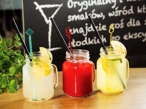 three drinks in mason jars on a table with a chalkboard at Ibis Warszawa Ostrobramska in Warsaw