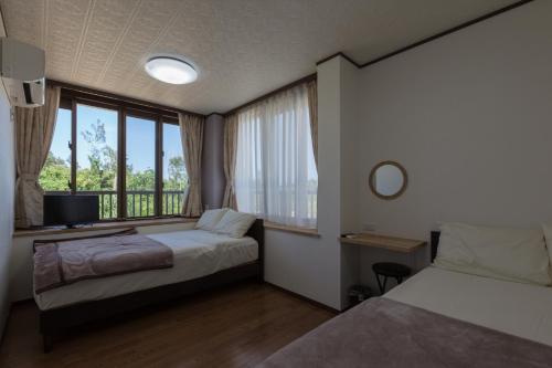 Gulta vai gultas numurā naktsmītnē Comfort House In Miyakojima
