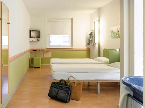a hospital room with two beds and a bag at Ibis budget Wien Sankt Marx in Vienna