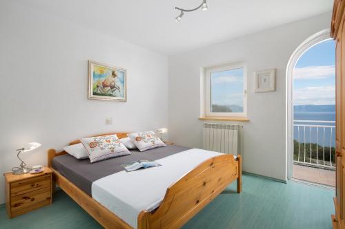 sypialnia z łóżkiem i dużym oknem w obiekcie Villa Bella Vista - apartments w mieście Labin