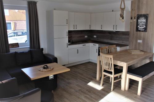 a kitchen and living room with a table and a couch at Ferienhausgebiet Oberlangen in Oberlangen