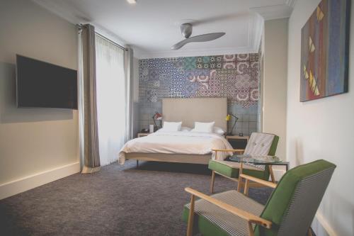 1 dormitorio con 1 cama, mesa y sillas en Hotel Mon Repos en Ginebra