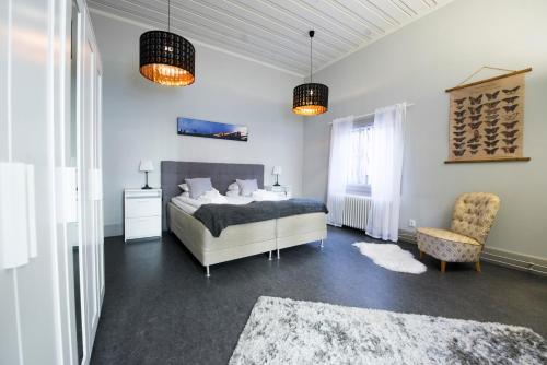 a bedroom with a bed and two lamps and a chair at Hotell Gamla Fängelset in Umeå