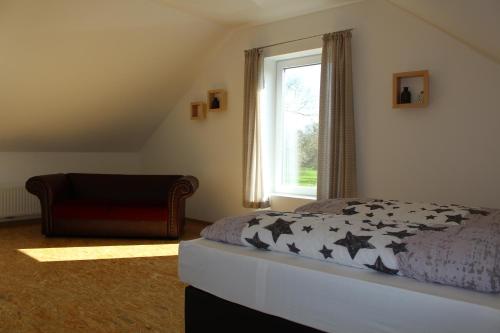 Schlafzimmer mit einem Bett und einem Fenster in der Unterkunft Ferienhaus Hof Beel in Oberlangen