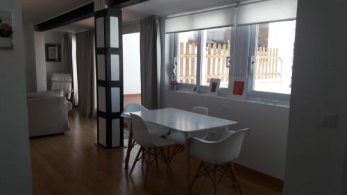 サフラにあるÁtico Torre Candelariaの窓付きの客室で、白いテーブルと椅子が備わります。