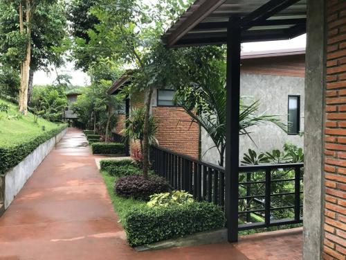 a walkway in front of a house with a fence at Sangkla Resort in Ban Sane Phong