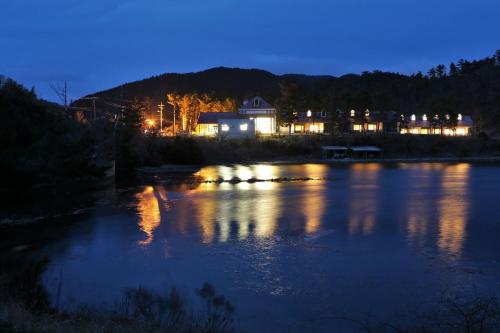 a river at night with a building in the background at Okinoshima Resort Island Park Hotel in Tsudo