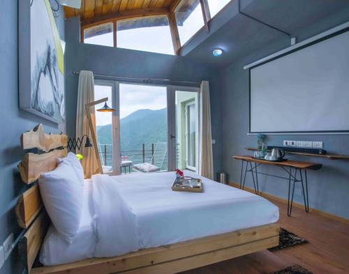 a bedroom with a large bed and a projection screen at Seclude Ramgarh Cliff's edge in Rāmgarh