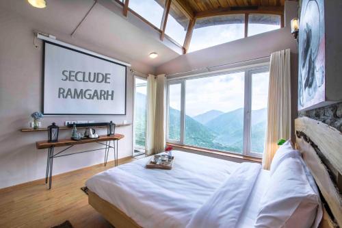 a bedroom with a large window with a large bed at Seclude Ramgarh Cliff's edge in Rāmgarh