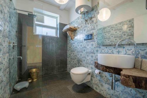 a bathroom with a toilet and a sink and a shower at Seclude Ramgarh Cliff's edge in Rāmgarh