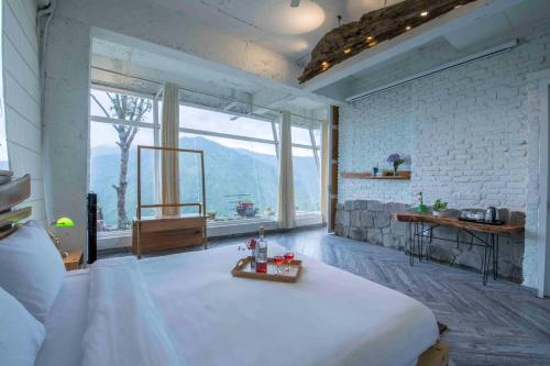 a bedroom with a bed and a large window at Seclude Ramgarh Cliff's edge in Rāmgarh