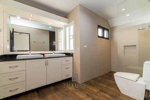 une salle de bain avec un lavabo, des toilettes et un miroir dans l'établissement 4 Bedroom Private Bali Style Villa HH6, à Hua Hin