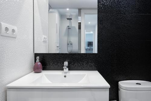 Un baño con lavabo, inodoro y espejo. en Seafront La Malagueta II, en Málaga