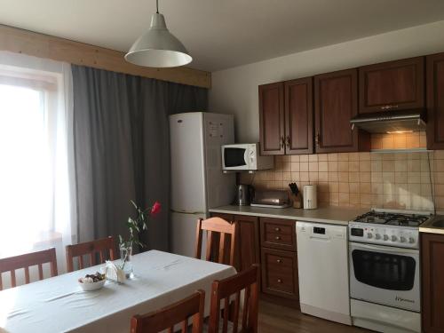 a kitchen with a table and a white refrigerator at Apartamenty w Jurgowie Świstokówka in Jurgów