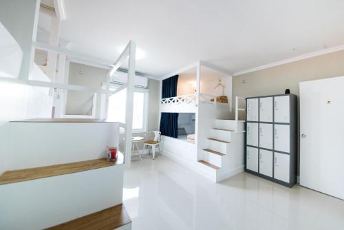 a room with white walls and a room with a bunk bed at The Partridge Guesthouse in Cebu City