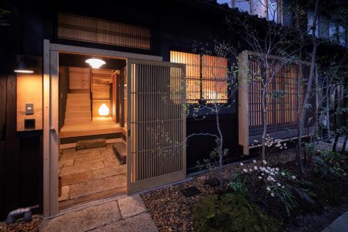 una entrada a una casa con una puerta de madera en Hotel Koo Otsuhyakucho en Otsu