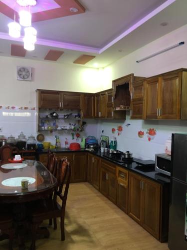 a kitchen with wooden cabinets and a table in it at Khánh Vân - VT Cloud mini Hotel in Vung Tau