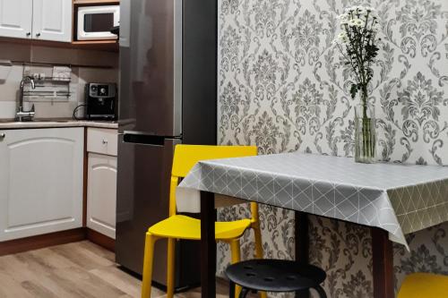 uma cozinha com uma mesa e duas cadeiras amarelas em Apartment - Heart of Odessa em Odessa