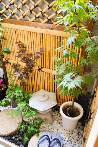 a garden with a wooden fence and a potted plant at Harper House in Osaka