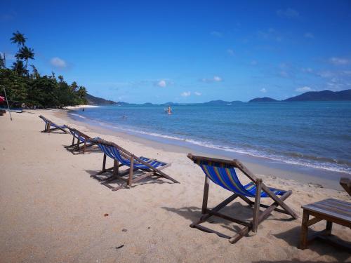 a row of chairs sitting on a beach at Yuyu Golden Beach in Ko Chang