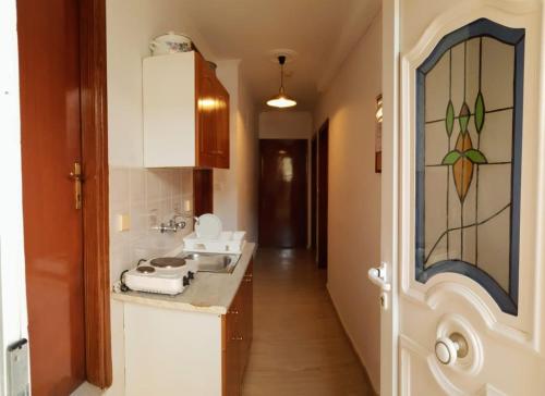 a kitchen with a sink and a counter with a stained glass window at Villa Kormos in Kavos