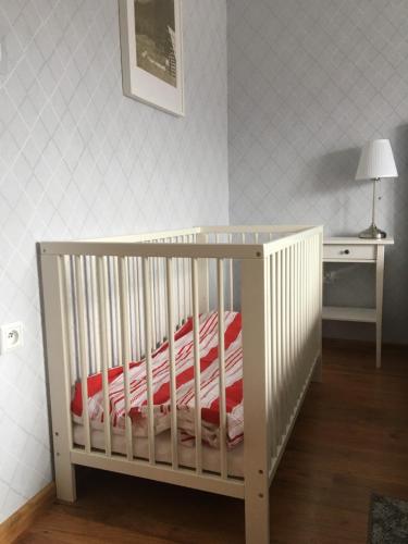 a crib in a room with a table and a lamp at Apartamenty w Jurgowie Świstokówka in Jurgów