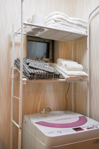 a bunk bed with a washing machine in a room at Harper House in Osaka