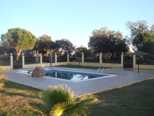 uma piscina num parque com um guarda-sol em San José em Andújar