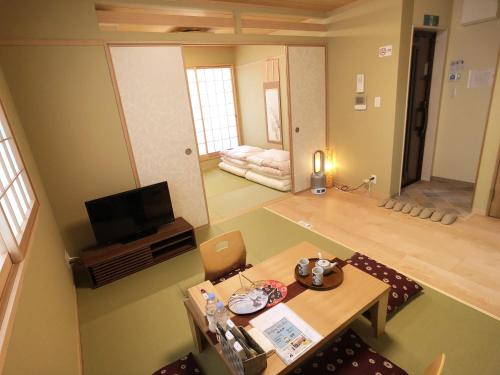 a view of a living room with a table and a television at Harper House in Osaka