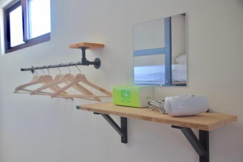 a wooden shelf with a mirror on a wall at Stay Liuqiu Diving Hostel in Xiaoliuqiu