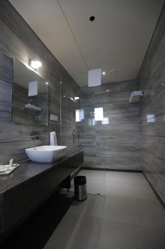 a bathroom with a sink and a glass shower at Hotel Radiance in Ahmadnagar
