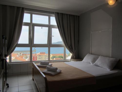 a bedroom with a bed and a large window at Cernogoriya voyage in Rafailovici