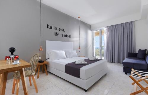 a bedroom with a king sized bed and a table and chairs at Vasia Royal Hotel in Gouves