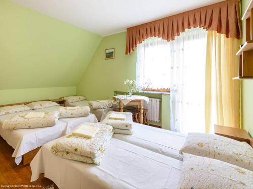 ザコパネにあるOśrodek Wypoczynkowy Helenaのベッド4台、テーブル、窓が備わる客室です。
