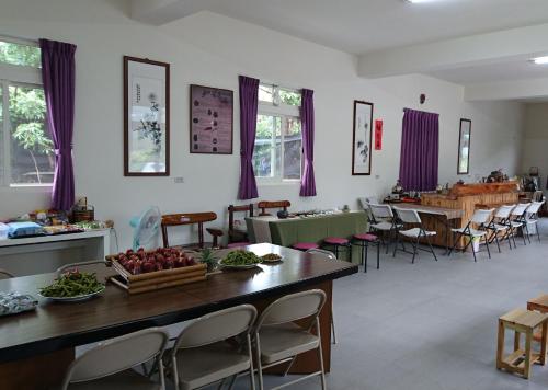 - une salle à manger avec des rideaux violets, une table et des chaises dans l'établissement Tian Ying Home Stay, à Liugui