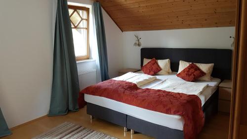 Schlafzimmer mit einem großen Bett mit roter und weißer Bettwäsche in der Unterkunft Mosthäusl in Wernstein am Inn