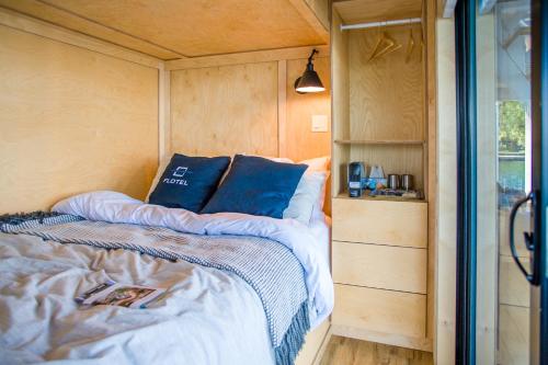 a bed with blue pillows in a tiny house at Flotel in Salaberry-de-Valleyfield