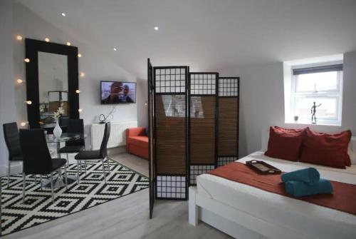 ロンドンにあるQuirky Cosy Marleybone Victorian Loft Apartmentのベッドルーム1室(ベッド1台付)、リビングルームが備わります。