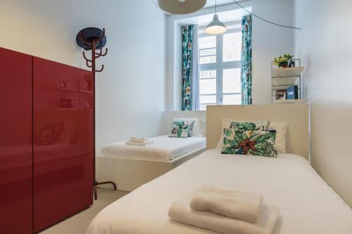 a bedroom with a white bed with a red cabinet at LovelyStay - Downtown Cosy Wonder in Lisbon