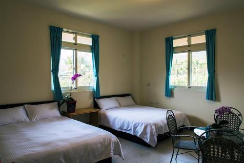 a bedroom with two beds and a table and chairs at Tian Ying Home Stay in Liugui