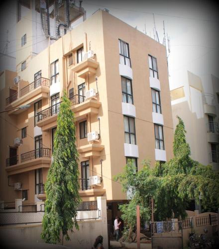 a large building with trees in front of it at Magnus Calypso Suites Viman Nagar in Pune