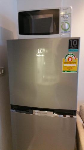 a microwave sitting on top of a refrigerator at Grandblue 311 in Mae Pim