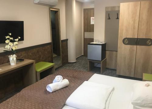 a hotel room with a bed with towels on it at Hotel Dolce Vita in Balatonkenese