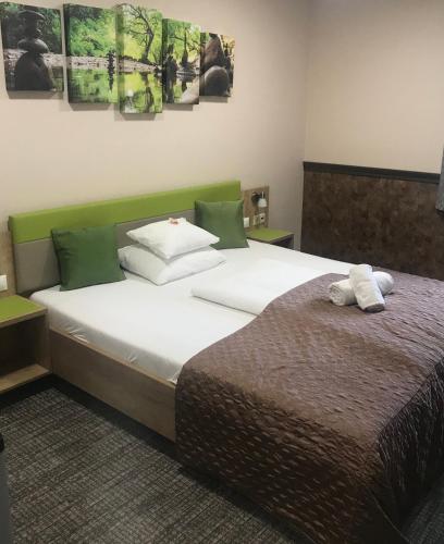 a bedroom with a large bed with two towels on it at Hotel Dolce Vita in Balatonkenese