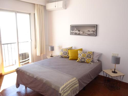 - une chambre avec un grand lit et des oreillers jaunes dans l'établissement Atico La Luz : Centre ville, rénové, terrasse, à Salobreña