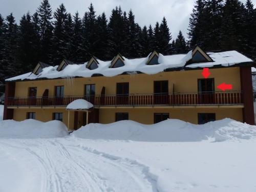 a house with a lot of snow in front of it at Apartman Poustevnik in Pec pod Sněžkou