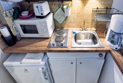 a small kitchen with a sink and a microwave at Ribizli Vintage Vendégház in Parád
